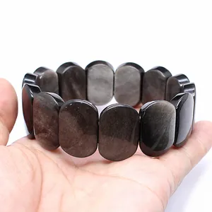 Macro detail of polished oval natural stone beads on a stretch bracelet hand row