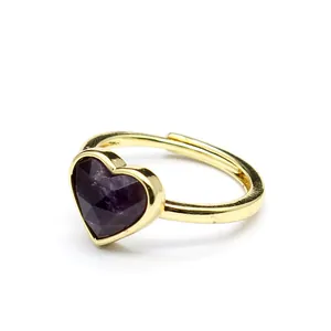 Close-up of a gold-plated open ring featuring a faceted purple heart-shaped stone detail.