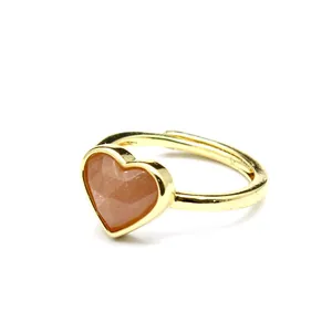 Detailed macro shot of a faceted heart-shaped natural stone set in a gold open ring