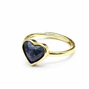 Close-up detail of a golden adjustable ring featuring a faceted heart-shaped blue natural stone.