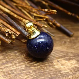 Dettaglio macro di un ciondolo porta olio essenziale in pietra blu da 16mm oro lucido.