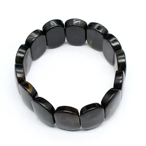 Macro detail of polished oval natural stone beads on a minimalist stretch bracelet