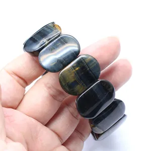 Close-up detail of smooth oval polished natural blue tiger eye stone hand bracelet