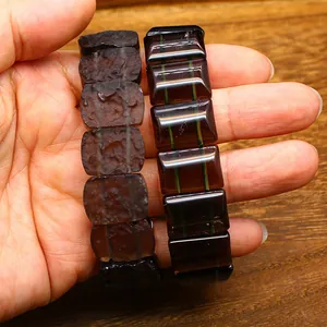 Close-up comparison of rough and polished Arizona tektite stone bracelets on a palm