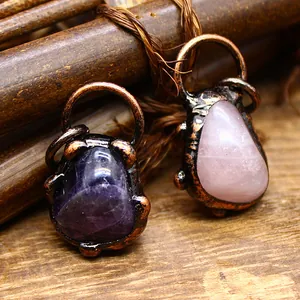 Detail von Vintage-Amethyst- und Rosenquarz-Anhängern mit rustikaler kupferfarbener Wicklung