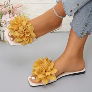 Stylish flat slide sandals featuring large yellow floral embellishments for summer wear
