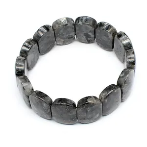 Detailed macro view showing smooth grey oval natural stone beads on a stretch bracelet band.