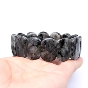 Detailed macro view of 11x18mm polished elliptical grey natural stone stretch bracelet