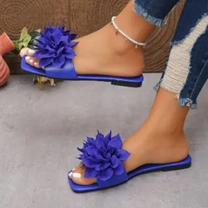 Blue flat sandals for women featuring large floral decorations on a square toe design