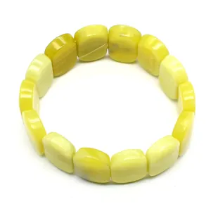 Detailed macro view of smooth oval yellow natural stone bracelet beads showing natural texture