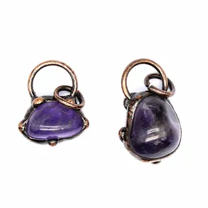 Detail von handgefertigten Amethyst-Rohstein-Anhängern mit antikem Kupferdraht gewickelt