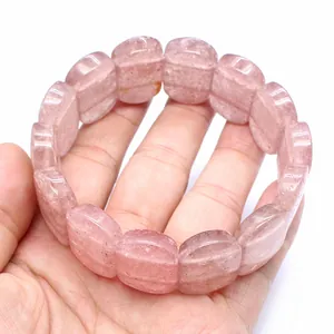 Close-up detail of a natural pink strawberry quartz bracelet featuring smooth oval beads