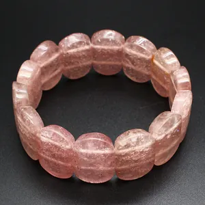 Detailed macro view of polished pink strawberry crystal oval beads on a stretch bracelet