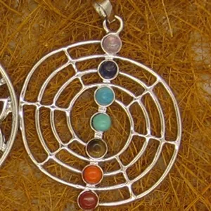 Detailed macro view of a silver-toned chakra spiral pendant with seven colorful gemstones