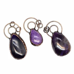 Detailreiche Makroaufnahme von Amethyst-Anhängern mit Vintage-Kupfer-Drahtwicklung