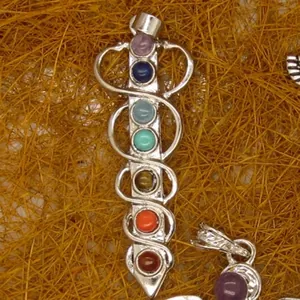Detailed view of seven chakra natural gemstone healing pendant with silver wire wrap