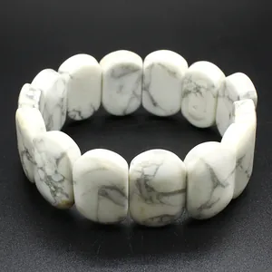 Macro view of polished white howlite oval beads on an elastic natural stone bracelet