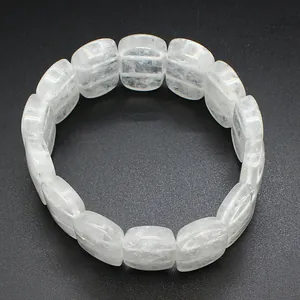 Close-up of polished white natural stone crystal hand-plate bracelet on dark background