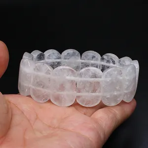 Macro detail of natural 11x18mm oval white crystal hand-row bracelet held in hand
