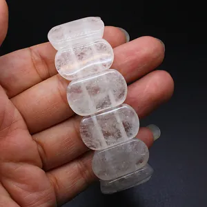 Close-up detail of a translucent natural clear quartz crystal bracelet with smooth oval beads