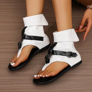 Detailansicht weißer High-Top-Zehensandalen mit schwarzen Riemen und Schnallen.