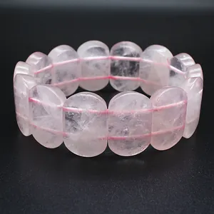 Close-up of polished oval pink rose quartz beads on a hand plate bracelet