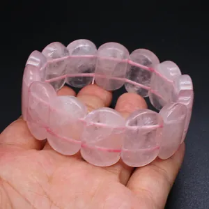 Macro detail of a natural rose quartz crystal hand row bracelet with oval smooth beads