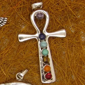 Silver Ankh pendant necklace with seven chakra stones on rustic background