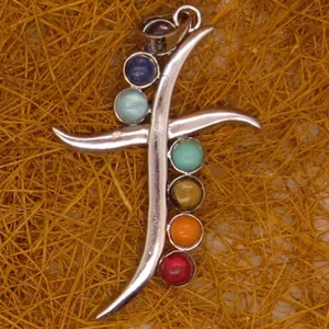 Close-up of sword-shaped pendant with seven colorful chakra stones