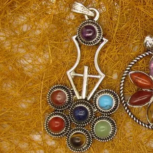 Close-up of a multicolor crystal gemstone sword pendant with intricate silver detailing