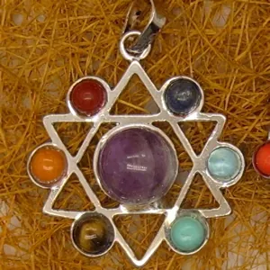 Detailed close-up of a silver hexagram pendant featuring seven colorful chakra gemstones.