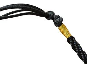 Détail macro d'un cordon de collier tressé noir avec enroulement de fil jaune