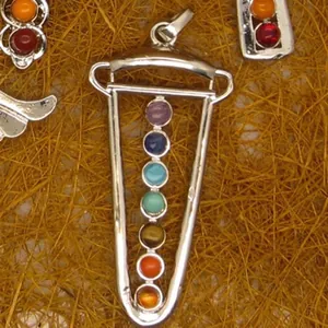 Detailed view of sword-shaped pendulum necklace with seven chakra crystal gemstones