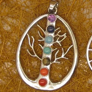 Detailed close-up of a silver tree of life pendant featuring seven colorful chakra gemstones