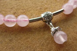 Detaillierte Nahaufnahme von rosa Rosenquarzperlen und silbernem Ethno-Anhänger