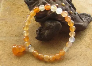 Gros plan d'un bracelet en agate rouge du Brésil avec un pendentif en calebasse.