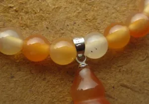 Détail macro montrant des perles d'agate rouge du Brésil et un pendentif en gourde