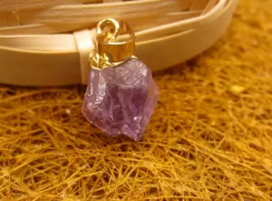 Gros plan détaillé montrant la texture brute d'un pendentif en améthyste du Brésil