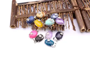 Group display of oval natural stone pendants with floral silver-colored metal accents