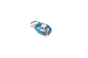 Macro view of an oval blue natural stone pendant with a delicate silver flower overlay.