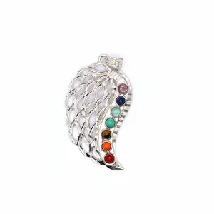 Close-up of silver angel wing pendant featuring seven chakra colored gemstones