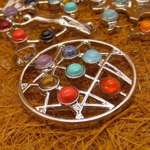 Geometric silver pendant necklace with colorful gemstone inlays on a natural background