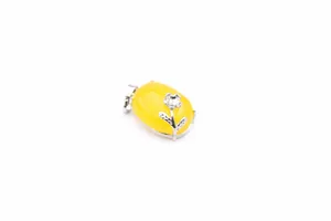 Close-up of a yellow natural stone pendant featuring a silver flower accent on white background