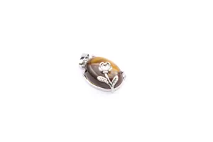 Natural tiger's eye stone pendant with silver rose flower decoration on white background