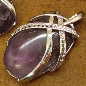 Natural oval amethyst crystal pendant with silver crisscross cage and sparkling accents