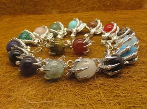Variety of unique dragon claw crystal pendants featuring assorted colorful gemstone spheres.