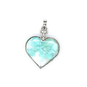 Primo piano di un ciondolo a forma di cuore in argento con pietre preziose blu chiaro