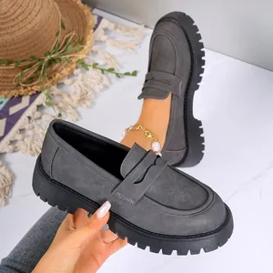 Detailed macro view of stylish grey platform loafers featuring a thick chunky sole and matte finish.