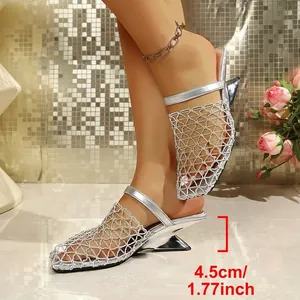 Détail de mules argentées à bout pointu en résille avec talon compensé géométrique de 4,5 cm