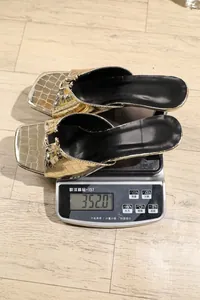 Gold metallic square toe sandals weighed on a digital scale showing 352 grams